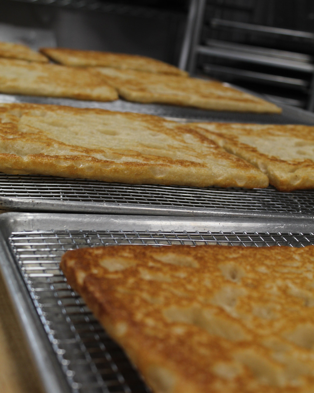 Par-baked crusts cooling on racks